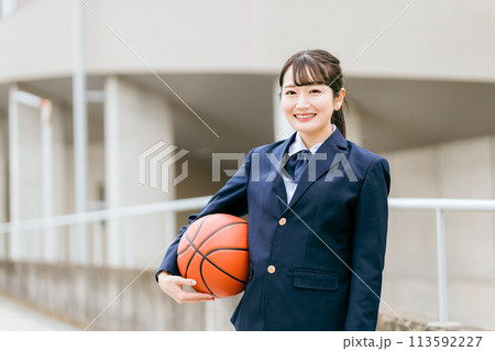 校舎の前でバスケットボールを持つ女子中学生・女子高生（部活・スポーツ・運動部・バスケ部） 113592227