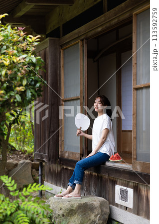 縁側でスイカを食べる可愛い女性 113592759