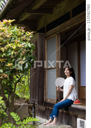 縁側でスイカを食べる可愛い女性 113592760