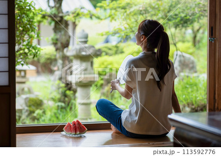 縁側でスイカを食べる可愛い女性 113592776