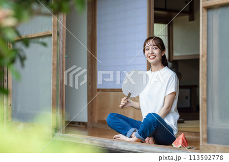 縁側でスイカを食べる可愛い女性 113592778