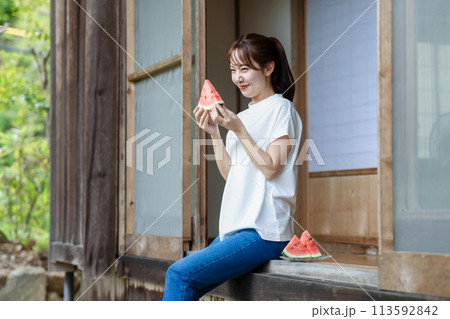 縁側でスイカを食べる可愛い女性 113592842