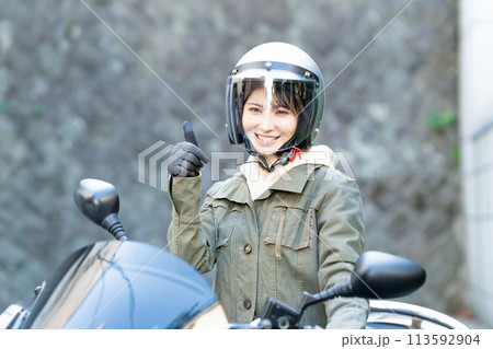 バイクに乗ってグッドサインをする女性 113592904