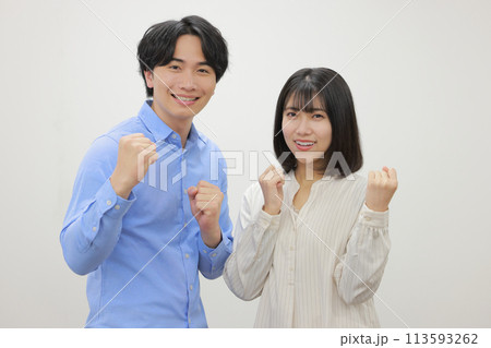 両手ガッツポーズで微笑むカジュアルな服の男女_1 113593262