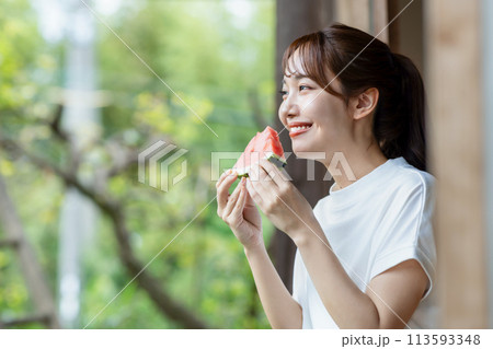 縁側でスイカを食べる可愛い女性 113593348