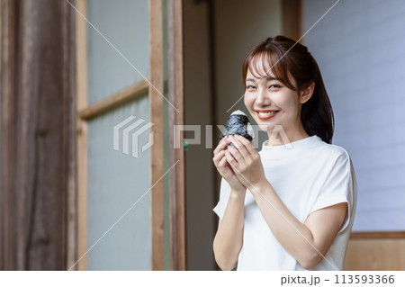 縁側でおにぎりを食べる可愛い女性 縁側でおにぎりを食べる可愛い女性 113593366