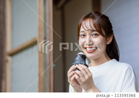 縁側でおにぎりを食べる可愛い女性 縁側でおにぎりを食べる可愛い女性 113593368