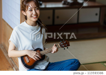 縁側でウクレレの練習をする女性 113593386