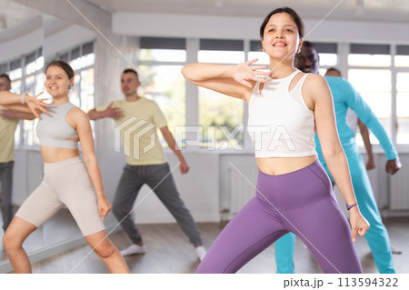 Young Asian woman practicing energetic dance at group class Young Asian woman practicing energetic dance at group class 113594322