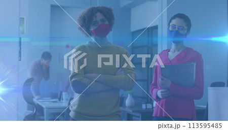 Image of glowing light trails over women in office talking and wearing face masks Image of glowing light trails over women in office talking and wearing face masks 113595485