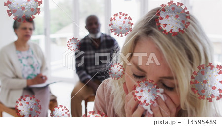Image of covid 19 cells over caucasian woman sneezing 113595489