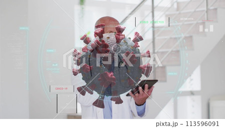 Image of covid 19 cell over senior male doctor using tablet wearing face mask 113596091