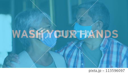Image of covid 19 text over senior couple embracing wearing face masks 113596097