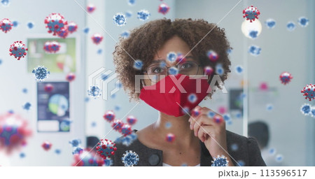 Image of covid 19 cells over woman in office wearing face mask Image of covid 19 cells over woman in office wearing face mask 113596517