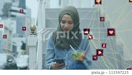 Image of a network of connected media icons with woman wearing hijab eating in street 113597225