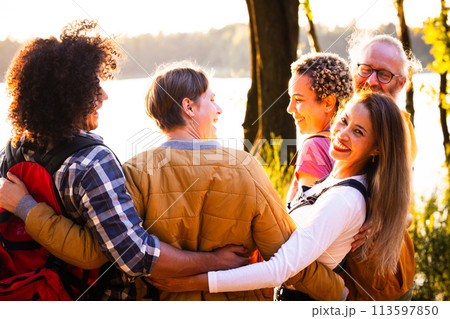 Warm Embrace: A Multigenerational Family Enjoying a Lakeside Sunset 113597850