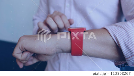 Young Caucasian man adjusts a red smartwatch on his wrist 113598267