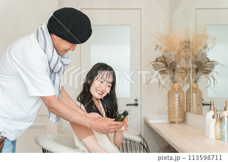 美容室・ヘアサロンの物販で商品を買う女性と美容師・スタイリスト 113598711