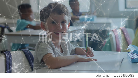 Image of networks moving over happy caucasian schoolboy working at desk class Image of networks moving over happy caucasian schoolboy working at desk class 113599085