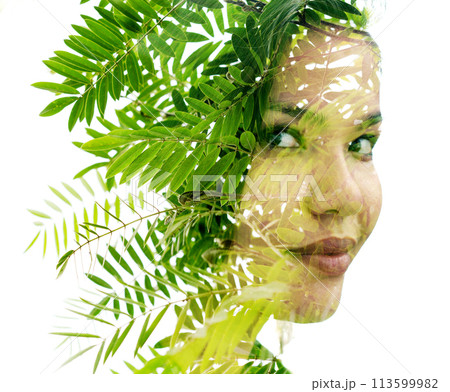 A double exposure woman's portrait merged with a photo of green leaves 113599982