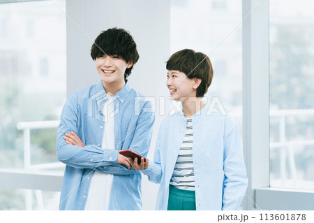 スマホを二人で見る若い男女 113601878