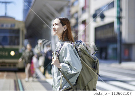 リュックを背負って歩く女性インバウンドバックパッカー 113602107