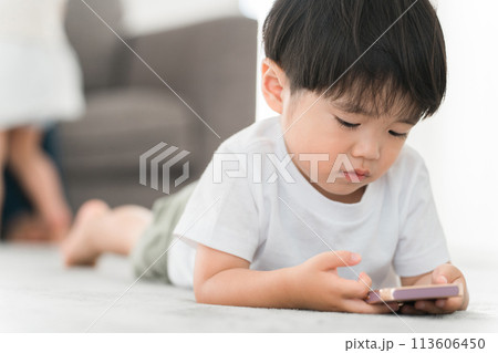 リビングでスマホで動画・ゲームをするアジア人の男の子 リビングでスマホで動画・ゲームをするアジア人の男の子 113606450