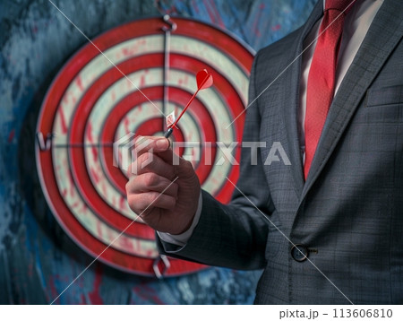 Successful businessman aiming for the target with a dart in hand 113606810