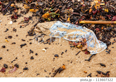 condom on the seashore close-up top view. ecological problems 113607322