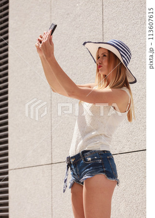 Young woman taking selfie with smartphone outside Young woman taking selfie with smartphone outside 113607615