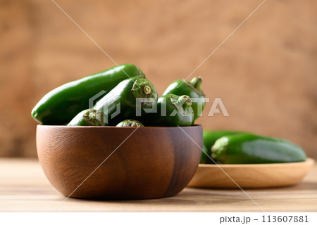 Fresh green Jalapeno chili in wooden bowl, Food ingredient 113607881