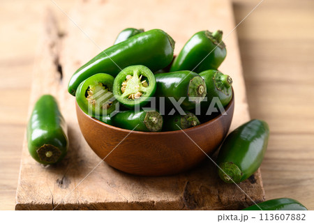 Fresh green Jalapeno chili in wooden bowl, Food ingredient 113607882