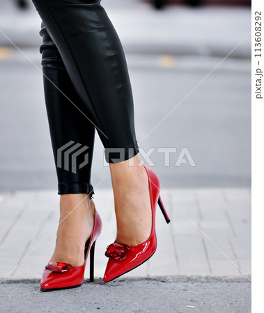 Lady with red high heel shoes and leather pants. Lady with red high heel shoes and leather pants. 113608292