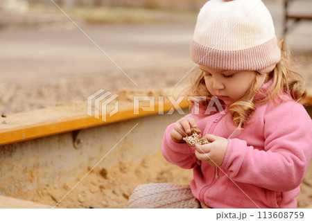 Cute toddler girl playing in sand on outdoor Cute toddler girl playing in sand on outdoor 113608759