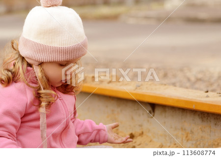 Cute toddler girl playing in sand on outdoor Cute toddler girl playing in sand on outdoor 113608774