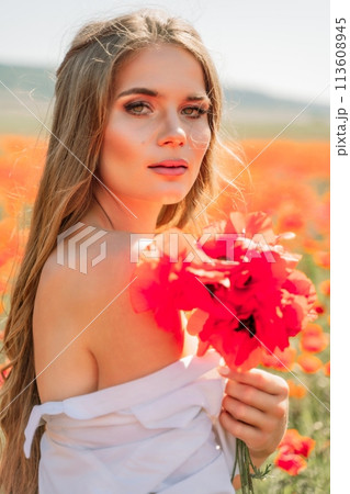 Woman poppies field. Side view of a happy woman with long hair in a poppy field and enjoying the beauty of nature in a warm summer day. 113608945