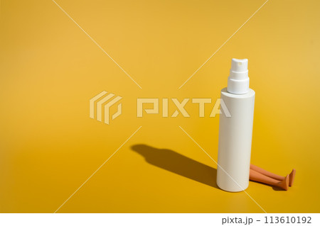 Blank white spray bottle with doll legs in direct sunlight Blank white spray bottle with doll legs in direct sunlight 113610192