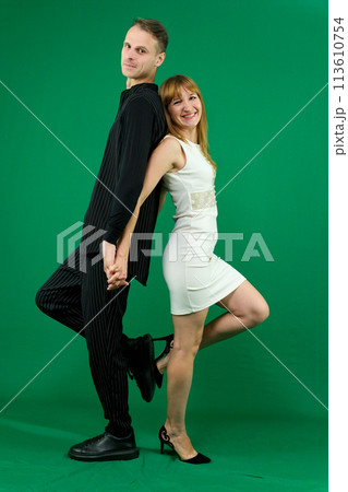 A man and a woman stand with their backs to each other against a green background, huddled close to each other. Yin-yang black white ,High quality photo A man and a woman stand with their backs to each other against a green background, huddled close to each other. Yin-yang black white ,High quality photo 113610754