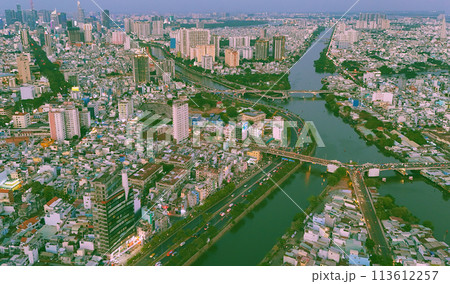 Aerial view from drone of Ho Chi Minh, big Asian city with row of crowded house, Nhieu Loc Thi Nghe canal, Y bridge cross water, vehicle traffic on road, level 4 house slum Aerial view from drone of Ho Chi Minh, big Asian city with row of crowded house, Nhieu Loc Thi Nghe canal, Y bridge cross water, vehicle traffic on road, level 4 house slum 113612257
