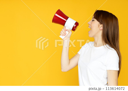 An attractive young girl with a loudspeaker in her hands An attractive young girl with a loudspeaker in her hands 113614072