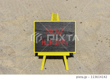Now hiring symbol. Concept words Now hiring on beautiful black chalk blackboard. Beautiful sea sand beach background. Business marketing, motivational now hiring concept. Copy space. Now hiring symbol. Concept words Now hiring on beautiful black chalk blackboard. Beautiful sea sand beach background. Business marketing, motivational now hiring concept. Copy space. 113614142