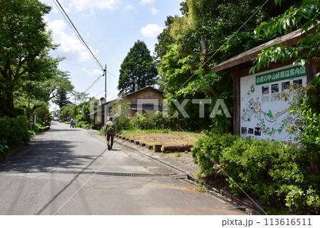 静岡県　東海道小夜の中山峠の案内板と新緑と旅人 113616511