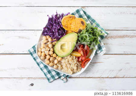 Healthy salad with avocado,lettuce,tomato and chickpeas on wooden table Healthy salad with avocado,lettuce,tomato and chickpeas on wooden table 113616986