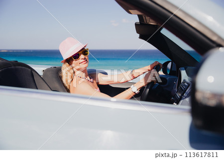 Happy woman travels by car on summer vacation 113617811