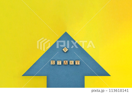 黄色の背景上のSTARTのアルファベットブロックと矢印をのせた青い矢印の正面 113618141