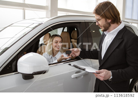 Happy Caucasian female client customer sitting inside new modern SUV car. 113618592