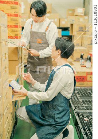 倉庫での軽作業をするエプロン姿の作業員 113619901