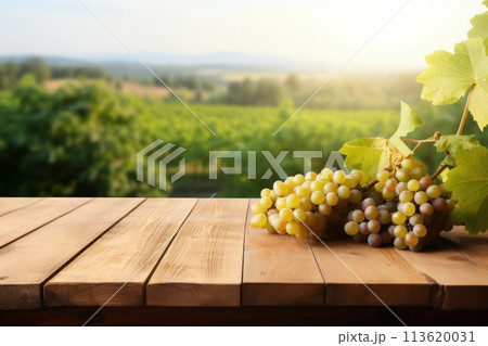 Empty wooden table top with grape and blurred background with field of vineyard. Mock up for wine product display. 113620031