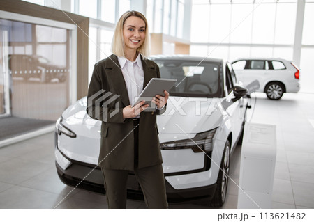 Professional salesperson working in bright and spacious car dealership. Professional salesperson working in bright and spacious car dealership. 113621482