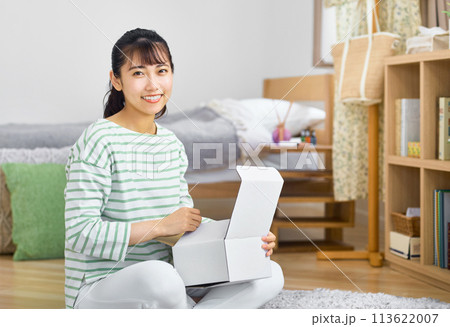 自宅でネットショッピングするカードとスマホを持った若い女性 113622007